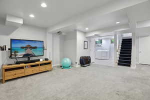 Workout area with light carpet, independent washer and dryer, and recessed lighting