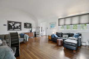 Living room featuring a barrel ceiling and dark wood finished floors