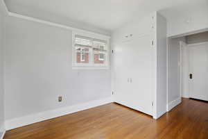 Unfurnished bedroom with wood finished floors and a closet