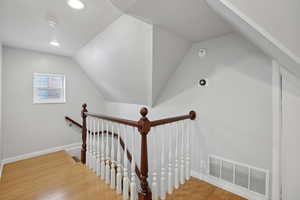 Stairs with wood finished floors and baseboards