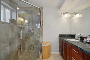 Bathroom with vanity, a shower stall, and light tile patterned floors
