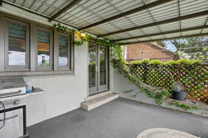 View of exterior entry featuring stucco siding and french doors