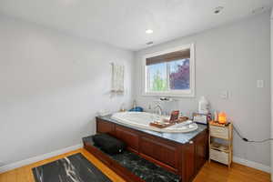Bathroom featuring a bath and light wood-style flooring