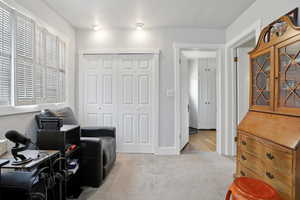 Living area with light colored carpet and baseboards