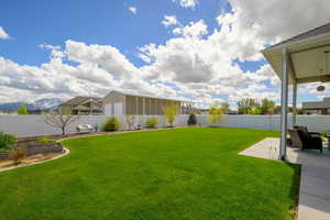 Fenced backyard with a mountain view, a patio area, and a garden