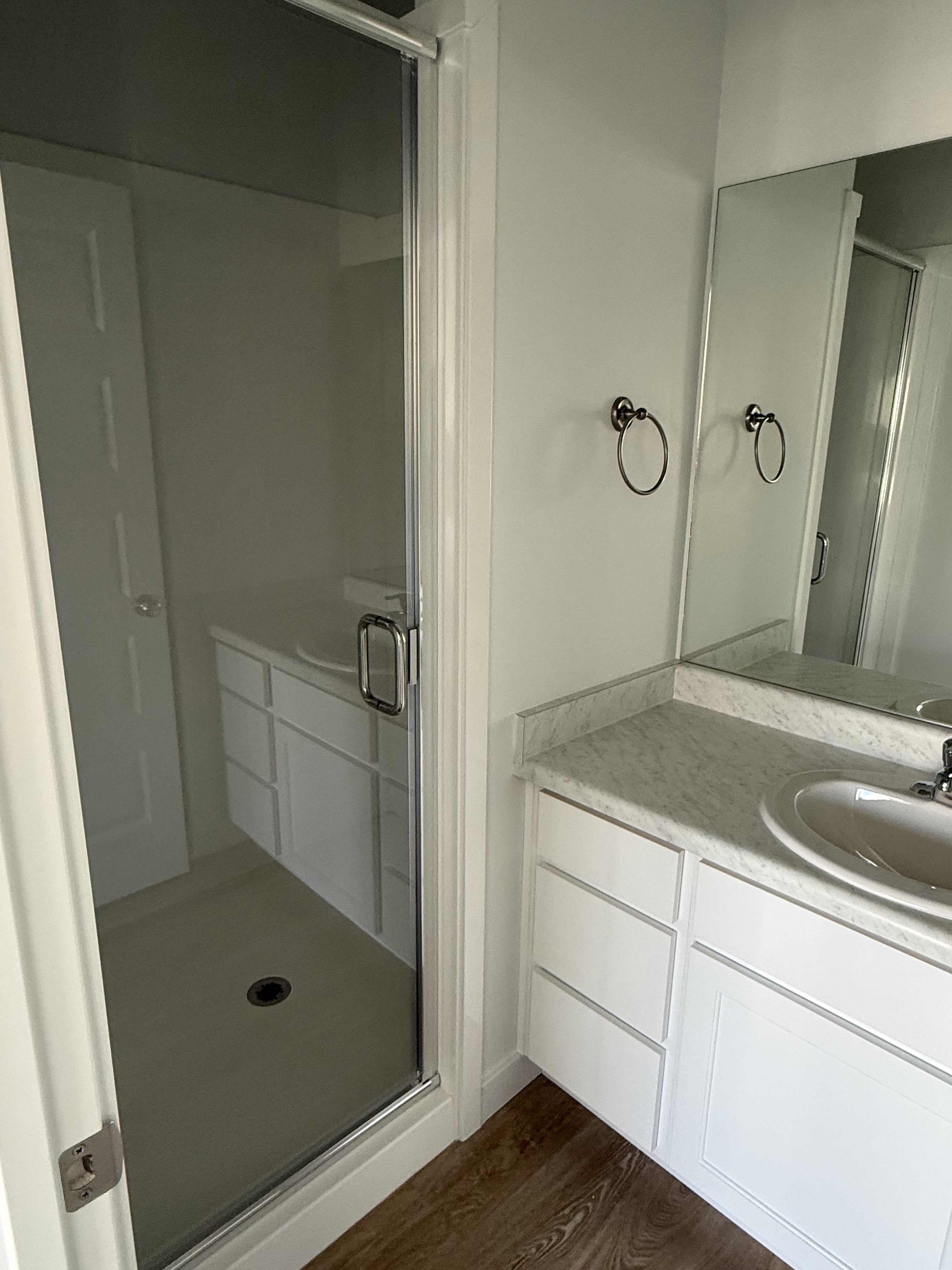 Bathroom featuring vanity, a shower stall, and dark wood-style flooring
