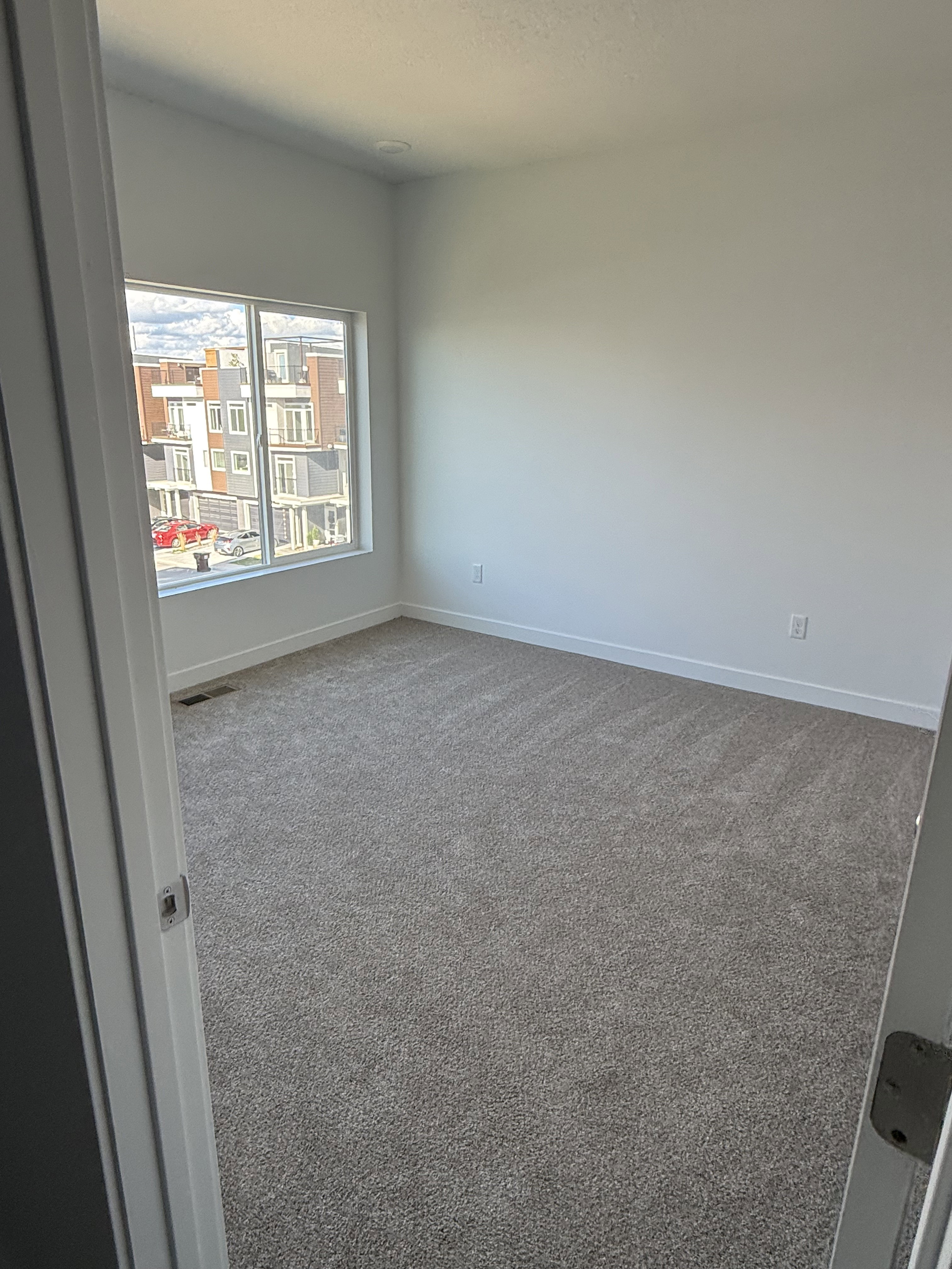 Spare room with dark carpet and baseboards