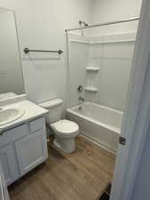 Bathroom featuring vanity, dark wood-style flooring, and shower / tub combination