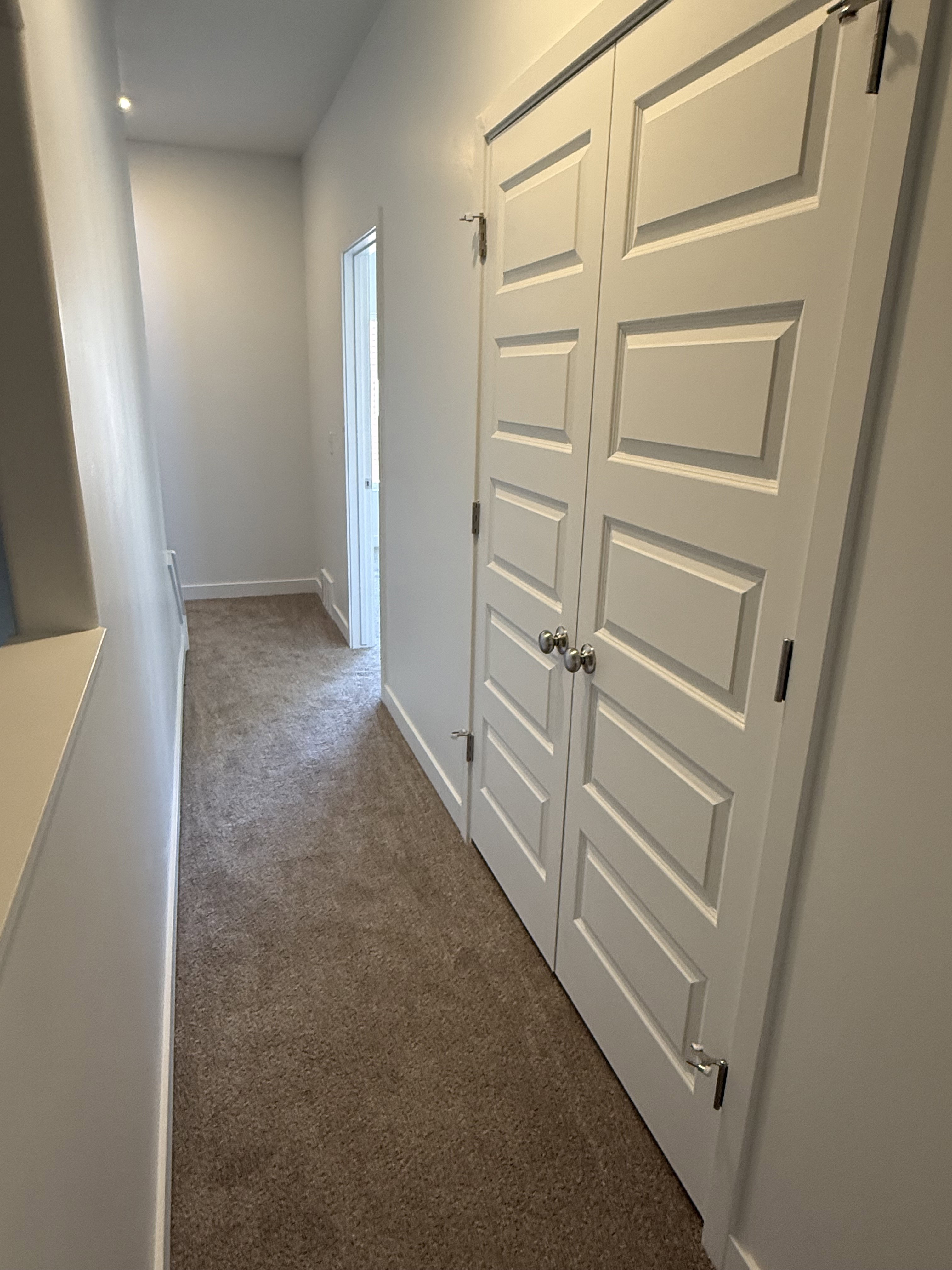 Hall featuring dark carpet and baseboards