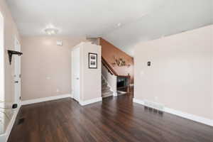 Spare room with stairs and dark wood finished floors