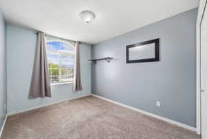 Carpeted spare room with baseboards