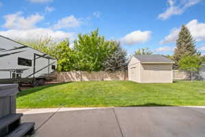 Fenced backyard with a storage shed