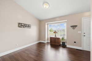 Foyer featuring dark wood-type flooring and lofted ceiling