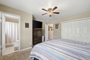 Bedroom with light colored carpet, a ceiling fan, and a closet