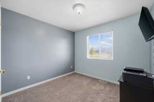 Unfurnished bedroom featuring light colored carpet and baseboards