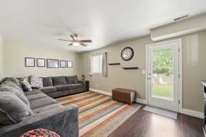 Living area with dark wood-type flooring and ceiling fan