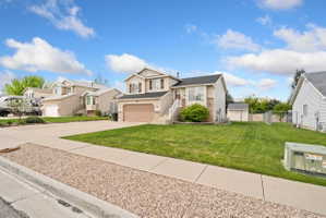 View of front of property with concrete driveway, a garage, and a residential view