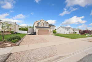 Traditional-style home featuring driveway, an attached garage, and stone siding
