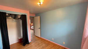 Unfurnished bedroom featuring a closet and light wood finished floors