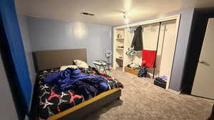 Bedroom featuring light colored carpet and a closet