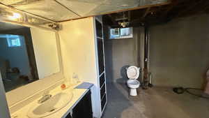 Bathroom with unfinished concrete floors and vanity