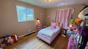 Bedroom featuring hardwood / wood-style floors and a textured ceiling