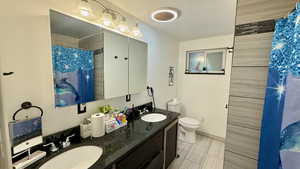 Bathroom with double vanity and a shower with shower curtain