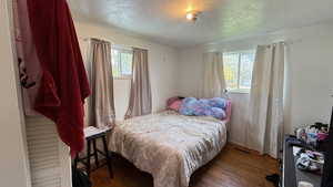 Bedroom with a textured ceiling and wood finished floors