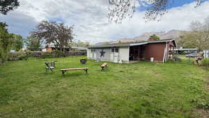 Back of property with a chimney, a gate, and brick siding