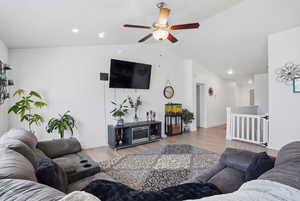 Living room with wood finished floors, lofted ceiling, ceiling fan, and recessed lighting