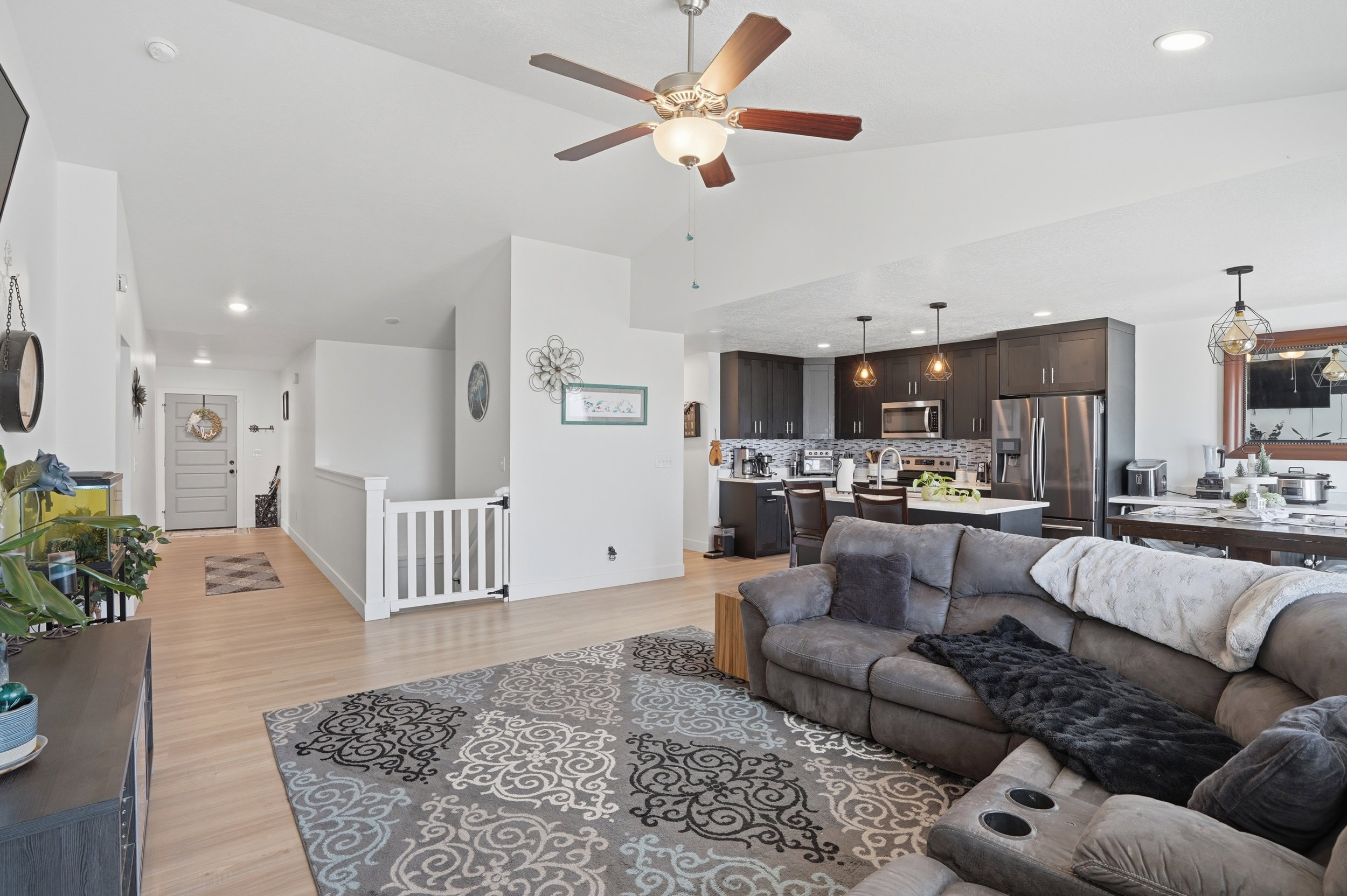 Living room featuring light wood-style flooring, recessed lighting, a ceiling fan, and vaulted ceiling