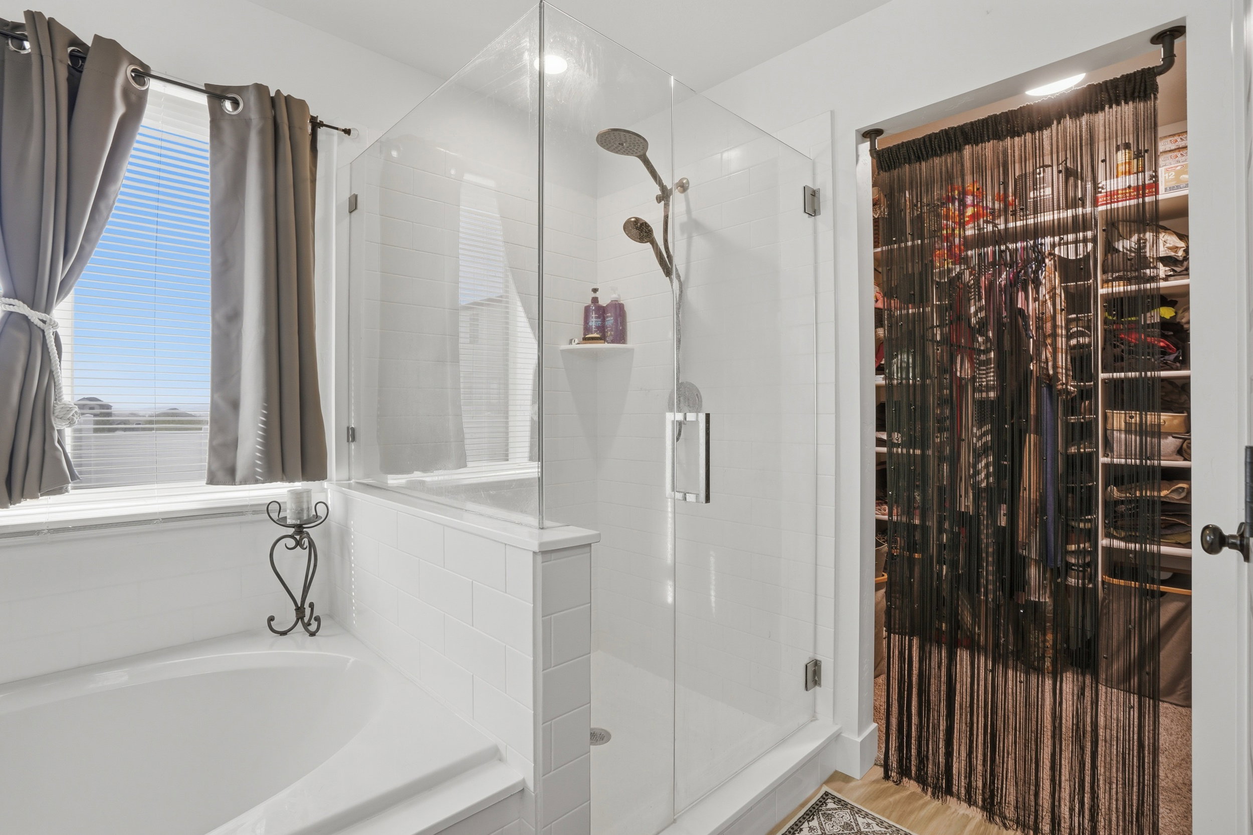 Bathroom featuring a spacious closet, a stall shower, and a bath