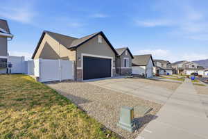 View of front facade featuring a gate, concrete driveway, a garage, a residential view, and stucco siding