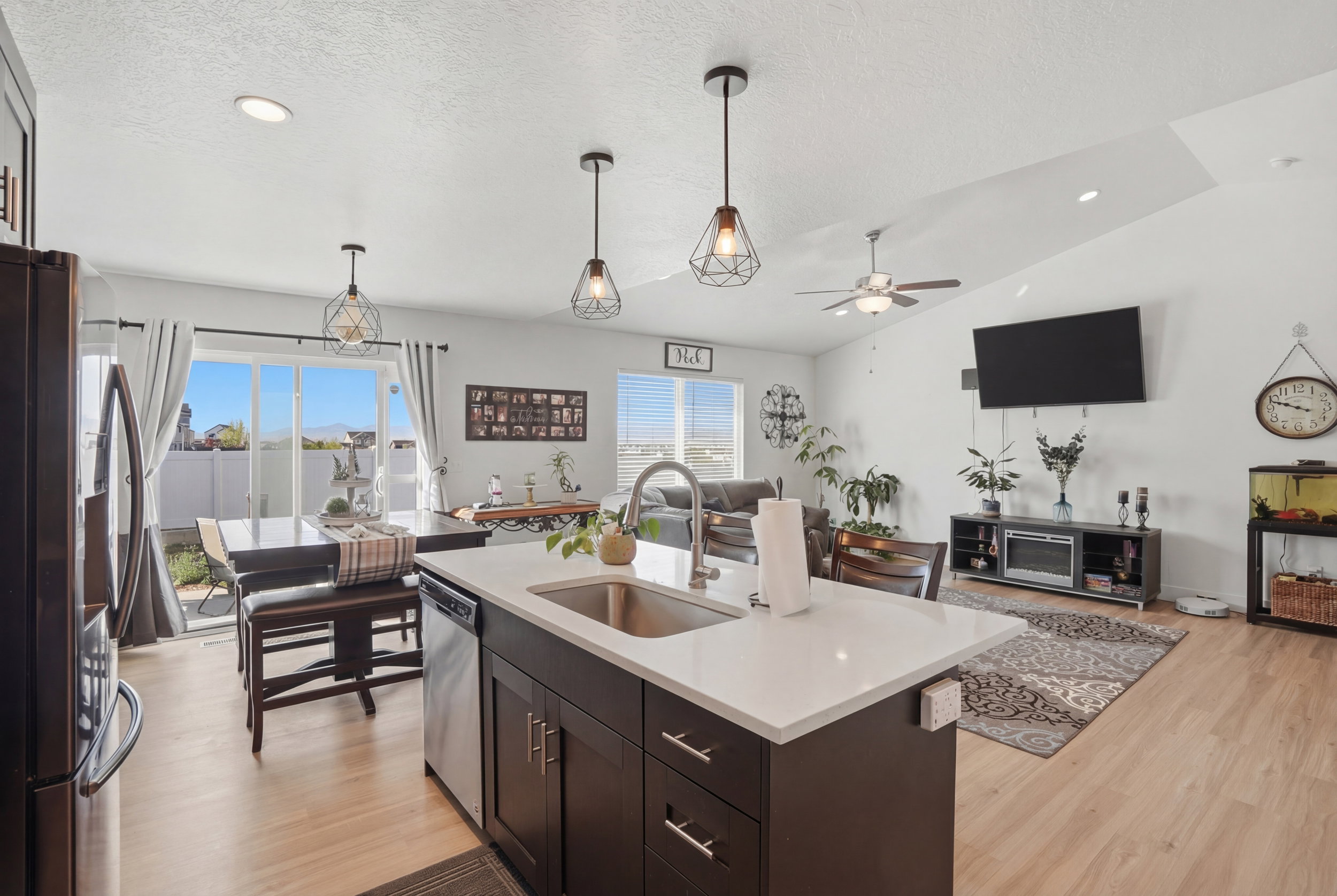 Kitchen featuring open floor plan, stainless steel appliances, hanging light fixtures, and light wood-type flooring