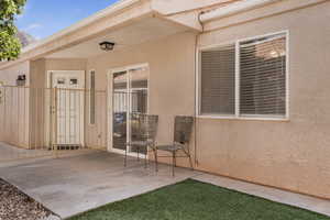 Property entrance with stucco siding and a patio area
