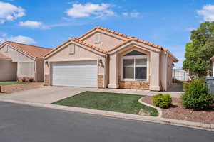 Mediterranean / spanish house featuring stone siding, concrete driveway, stucco siding, and a garage