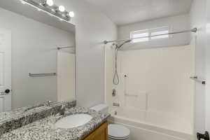 Full bathroom featuring vanity, washtub / shower combination, and a textured ceiling