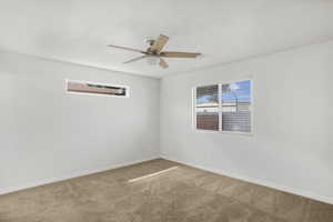 Empty room featuring carpet floors and ceiling fan