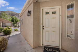 Entrance to property with a mountain view and stucco siding