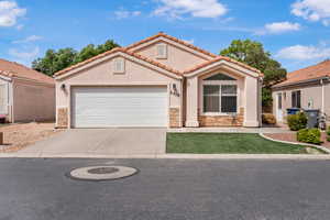 Mediterranean / spanish-style home with stone siding, concrete driveway, a garage, and stucco siding