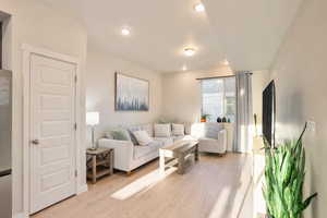 Living area with light wood-type flooring and recessed lighting