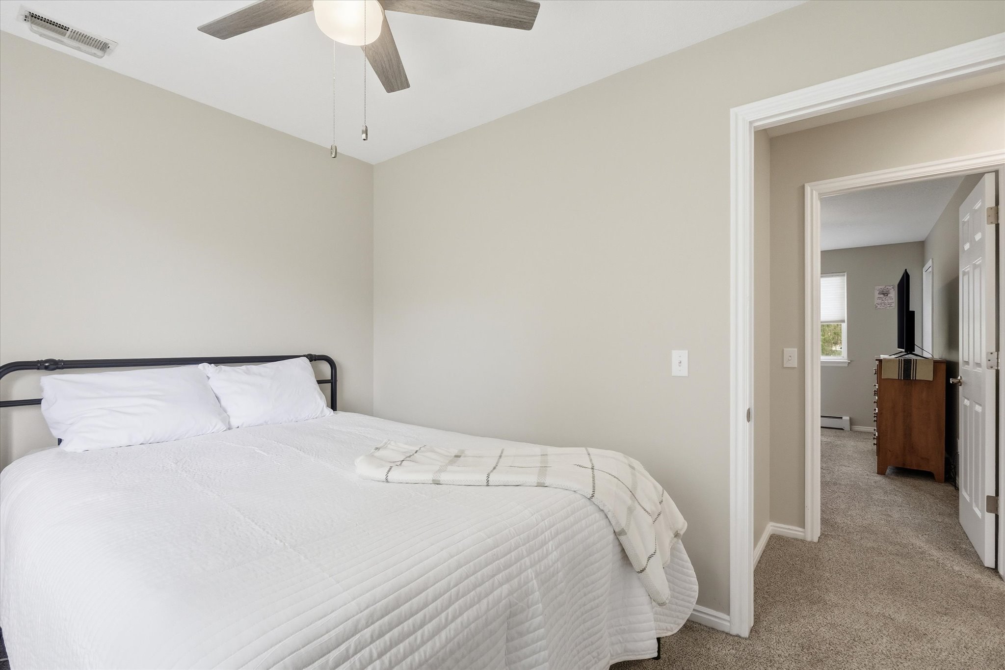 Bedroom featuring carpet flooring, a ceiling fan, and a baseboard radiator