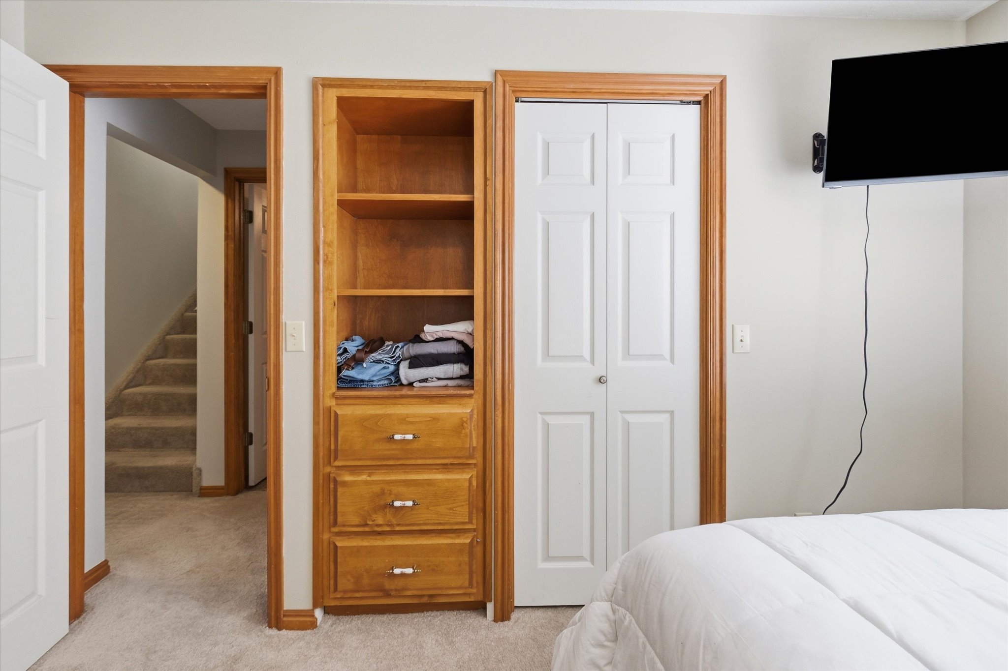 Bedroom with light colored carpet and a closet