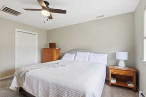 Carpeted bedroom featuring a closet and a ceiling fan