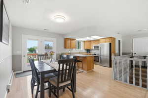 Dining space featuring light wood finished floors and baseboard heating
