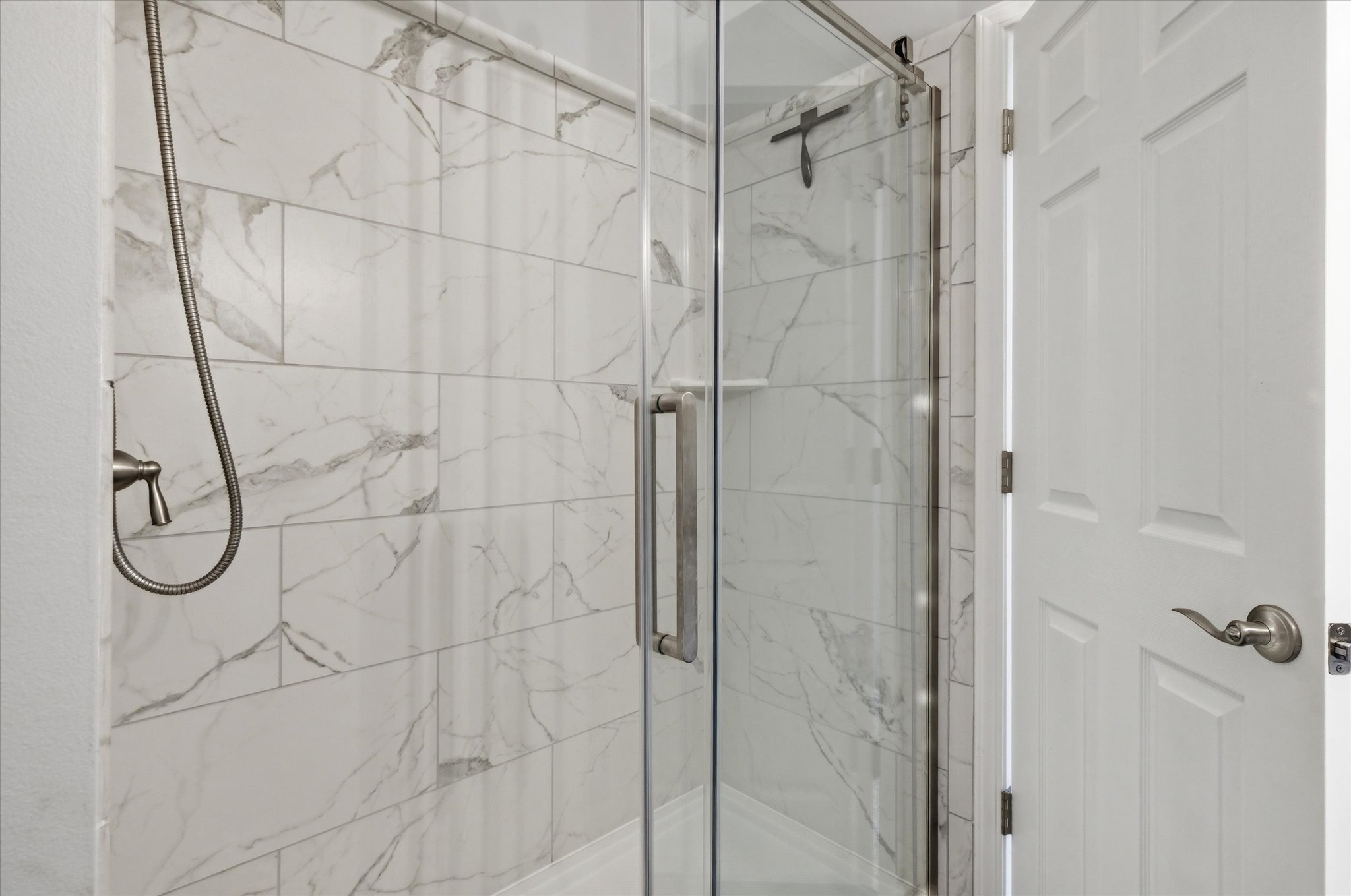 Bathroom with a marble finish shower