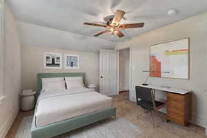 Carpeted bedroom with vaulted ceiling and ceiling fan