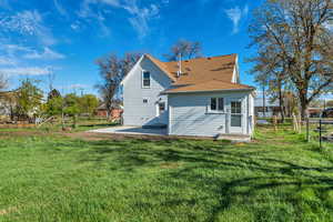 Rear view of house featuring roof with shingles and a patio
