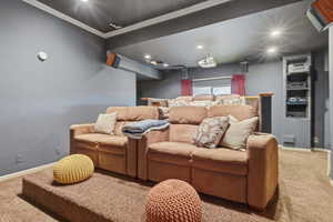 Home theater room featuring carpet, recessed lighting, and crown molding