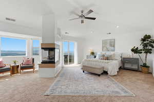 Bedroom with light colored carpet, lofted ceiling, a ceiling fan, and a water view